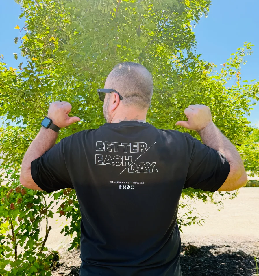 The back of Jon's shirt, reading Better Each Day, 1 percent.